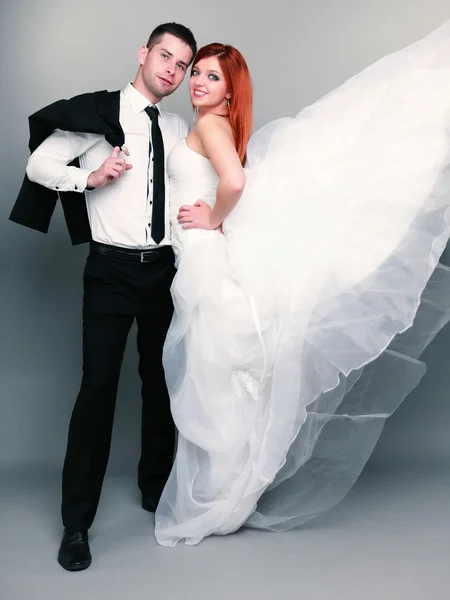 Feliz casal noivo noiva no fundo cinza — Fotografia de Stock