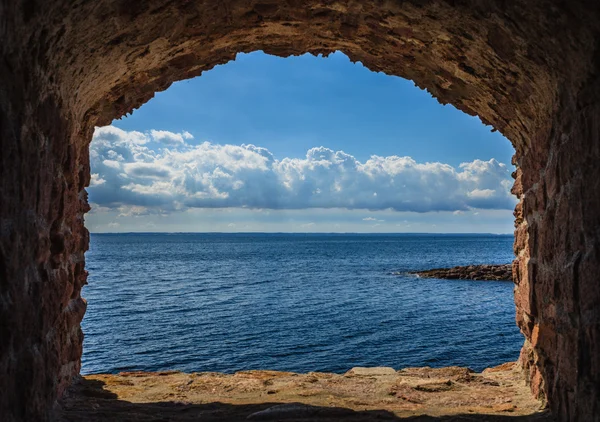 蓝色的大海海景从孔窗框在老石墙的视图 — 图库照片