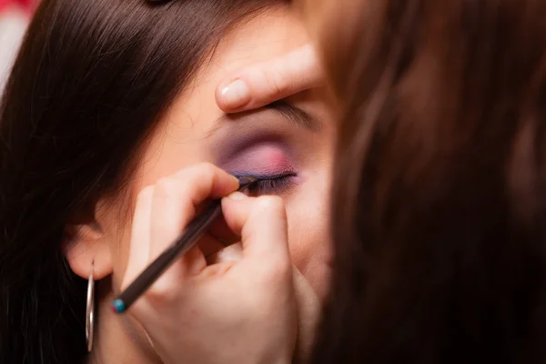 Maquillaje artista aplicación con sombra de ojos cepillo en el párpado de la mujer — Foto de Stock