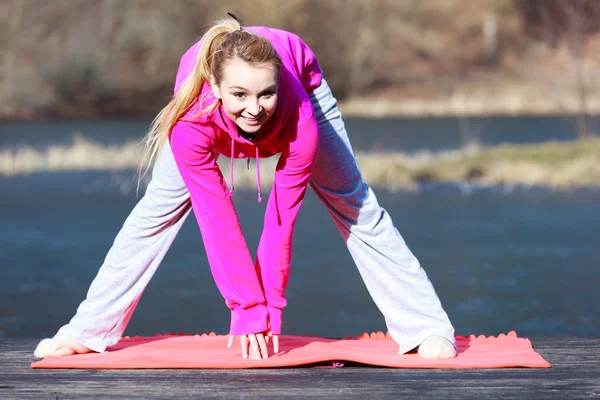 Девушка-подросток в спортивном костюме делает упражнения на открытом пирсе — стоковое фото