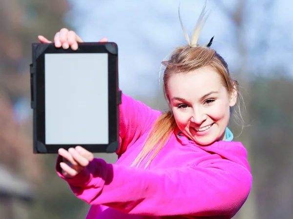 Woman teenage girl in pink tracksuit showing blank tablet outdoor — Stock Photo, Image