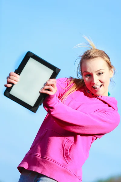 Жінка-підліток дівчина в рожевому костюмі, що показує порожній планшет на відкритому повітрі — стокове фото