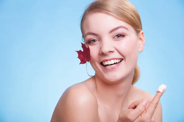 Soins de la peau. Visage de jeune femme fille avec feuille d'érable rouge. — Photo