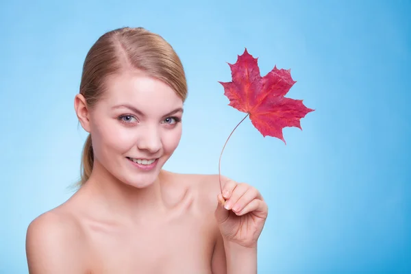 Soins de la peau. Portrait de jeune femme fille avec feuille d'érable rouge. — Photo