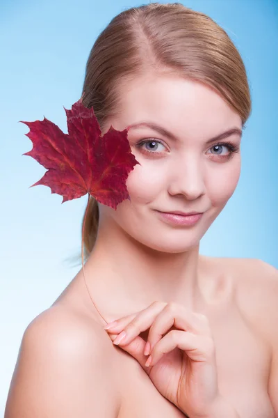 Huidverzorging. Portret van een meisje met een rood esdoornblad. — Stockfoto