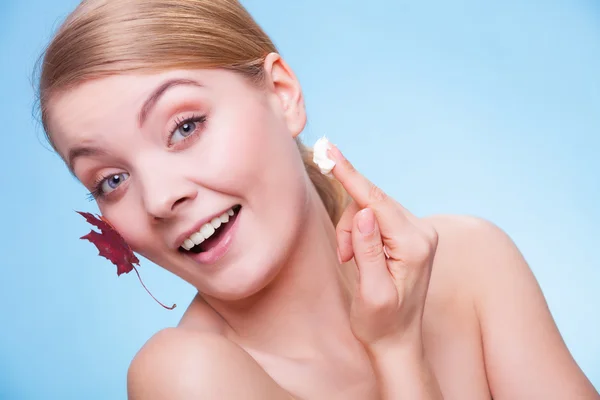 Soins de la peau. Visage de jeune femme fille avec feuille d'érable rouge. — Photo