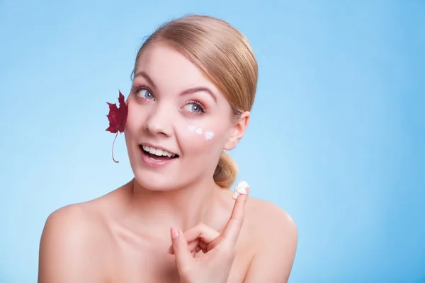 Cuidado de la piel. Cara de chica joven con hoja de arce rojo. — Foto de Stock