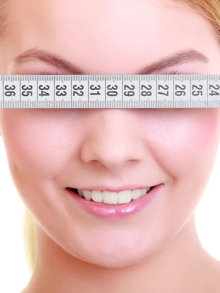 Fitness girl fit woman covering her eyes with measuring tape — Stock Photo, Image
