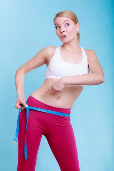 Fitness woman fit girl with measure tape measuring her loins — Stock Photo, Image