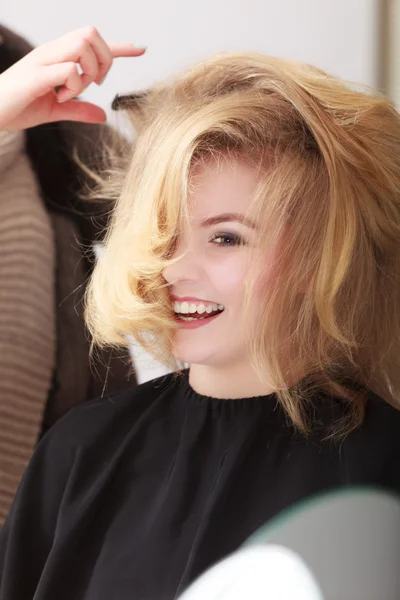 Cabeleireiro penteando cliente feminino menina loira no salão de cabeleireiro — Fotografia de Stock