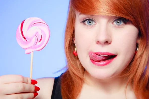 Sexig ung kvinna med godis. Rödhårig flicka äter söt klubba — Stockfoto