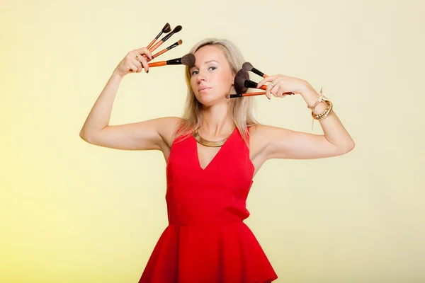 Procedimentos de beleza, mulher mantém pincéis de maquiagem perto do rosto . — Fotografia de Stock