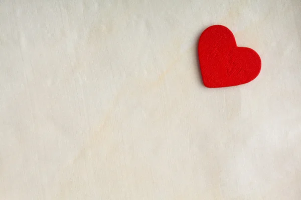 Corazón decorativo rojo de madera sobre fondo de tela blanca . — Foto de Stock