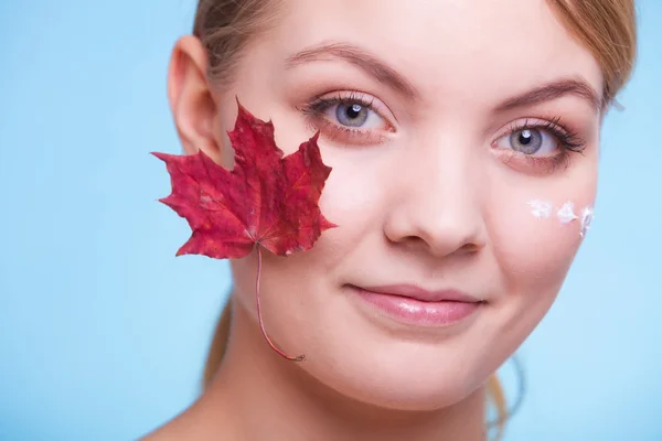 Cura della pelle. Volto di giovane donna ragazza con foglia d'acero rosso. — Foto Stock