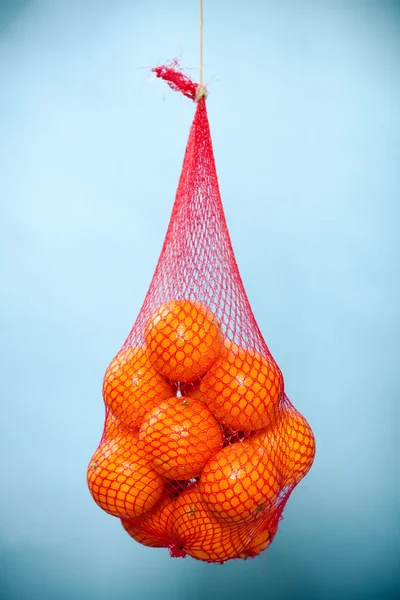 Čerstvé pomeranče plody v síťovině ze supermarketu — Stock fotografie