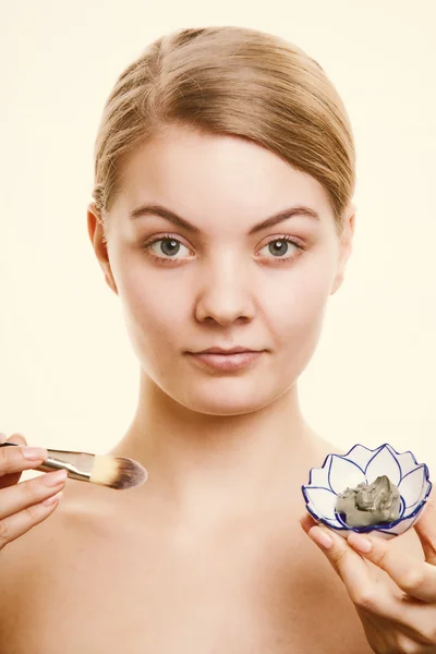 Skin care. Woman applying clay mask on face. Spa. — Stock Photo, Image