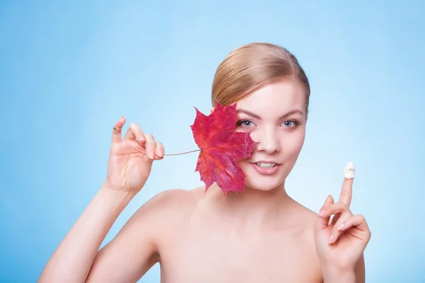 Soins de la peau. Visage de jeune femme fille avec feuille d'érable rouge. — Photo