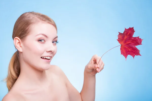 Huidverzorging. Portret van een meisje met een rood esdoornblad. — Stockfoto