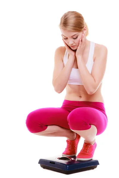 Fitness woman sporty girl on scale worried with her weight — Stock Photo, Image