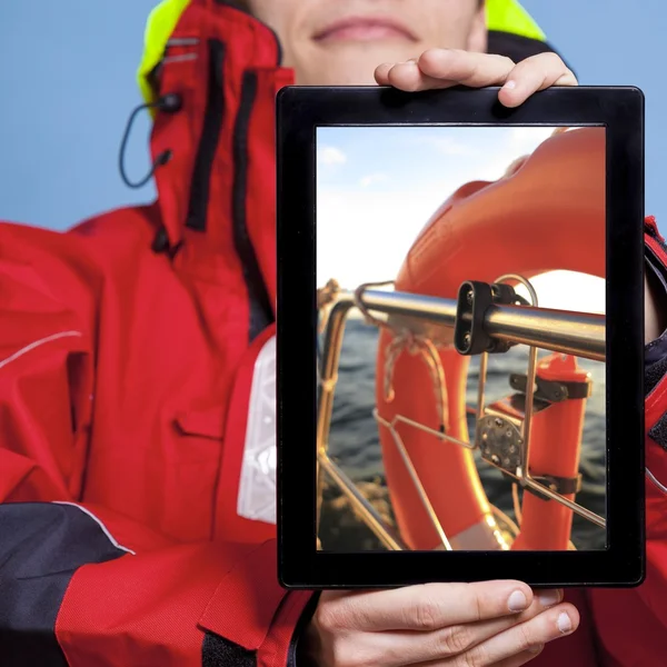 男人水手在平板电脑上显示救生圈。帆船 — 图库照片