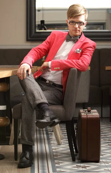 Young handsome stylish man with suitcase waits — Stock Photo, Image