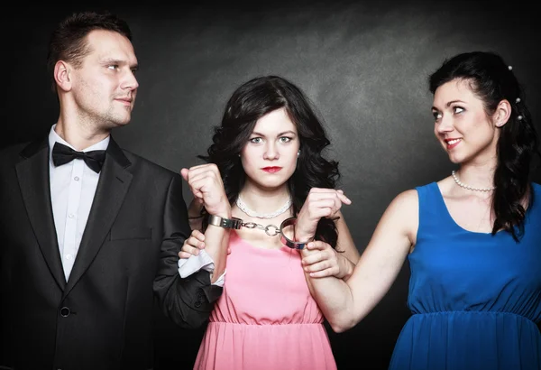 Two elegant women with gun gangster in handcuffs — Stock Photo, Image