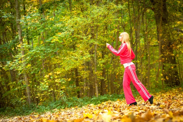 가을 숲 공원에서 조깅하고 있는 금발 소녀 — 스톡 사진