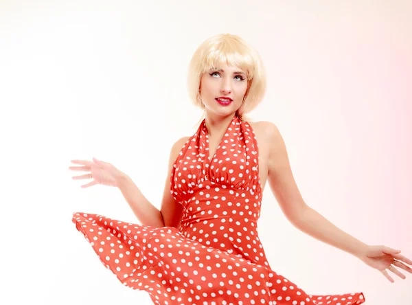 Beautiful pinup girl in blond wig and retro red dress dancing. Party. — Stock Photo, Image