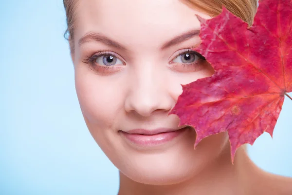 Skin care. Portrait of young woman girl with red maple leaf. — Stock Photo, Image