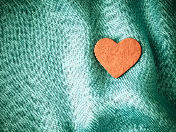 Valentýna pozadí. Červené srdce na modré záhyby látky — Stock fotografie