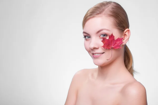 Cuidado de la piel. Retrato de chica joven con hoja de arce rojo. —  Fotos de Stock
