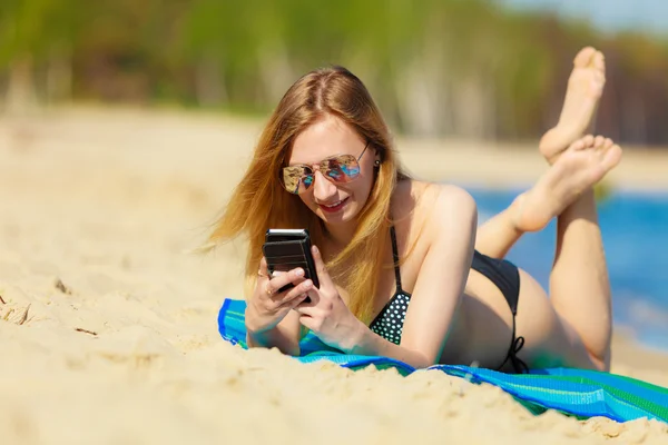 Vacaciones de verano Chica con teléfono bronceado en la playa — Foto de Stock