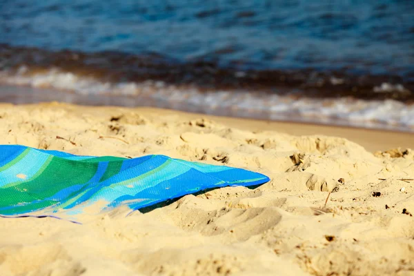 Wakacje. Pusty niebieski zielony mat na plaży — Zdjęcie stockowe