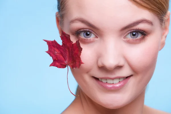 Skin care. Portrait of young woman girl with red maple leaf. — Stock Photo, Image