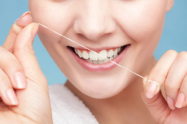 Chica limpiando dientes con hilo dental. Asistencia sanitaria —  Fotos de Stock