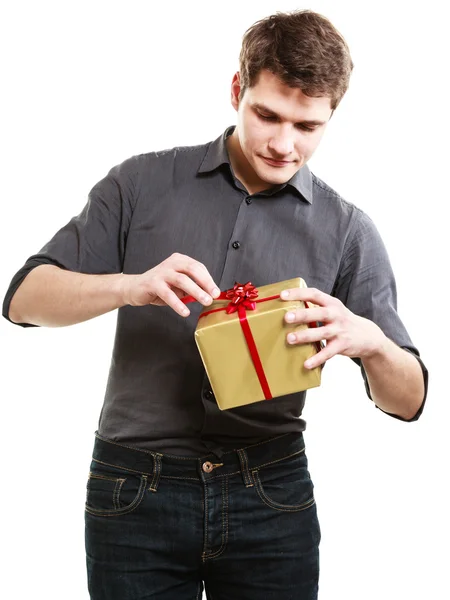 Holiday. Man got golden gift box with red ribbon — Stock Photo, Image