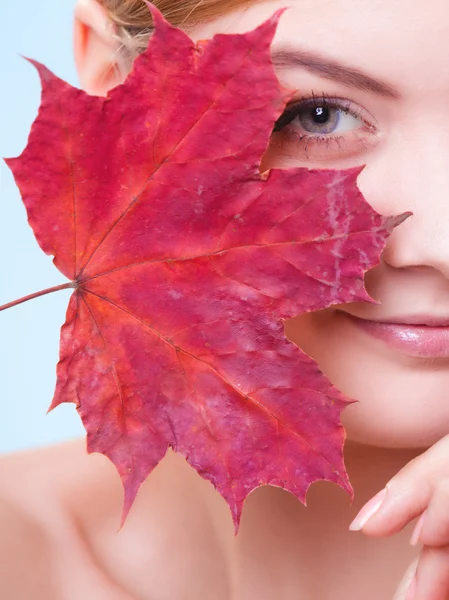 Soins de la peau. Portrait de jeune femme fille avec feuille d'érable rouge. — Photo