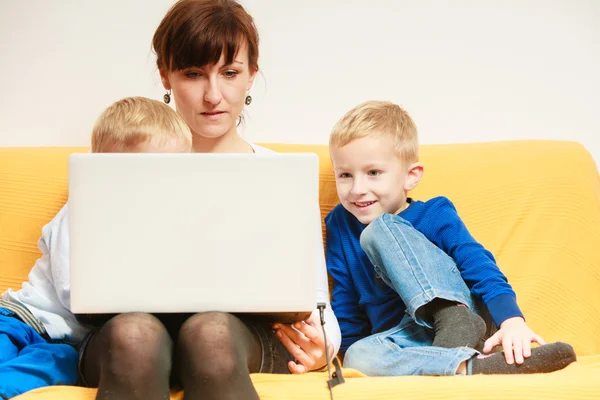 幸福的家庭。母亲和儿子使用笔记本电脑坐在家里的沙发上 — 图库照片