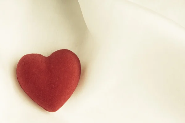 Coração decorativo de madeira vermelho no fundo de seda branca . — Fotografia de Stock