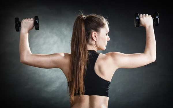 Fitness dziewczyna trening mięśni barków ciężarkach widok z tyłu — Zdjęcie stockowe