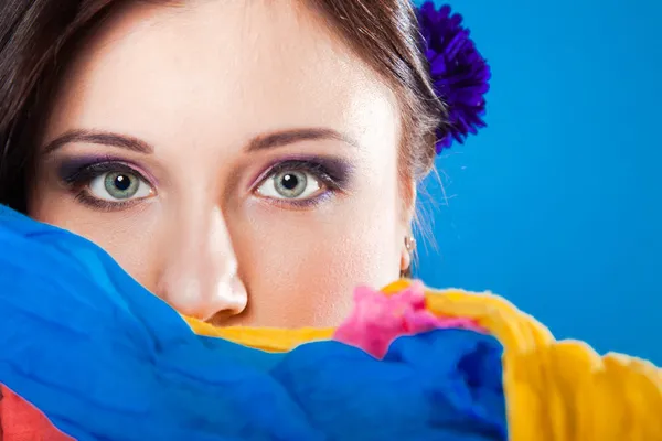 Женщина прячет лицо с платком на голубом — стоковое фото