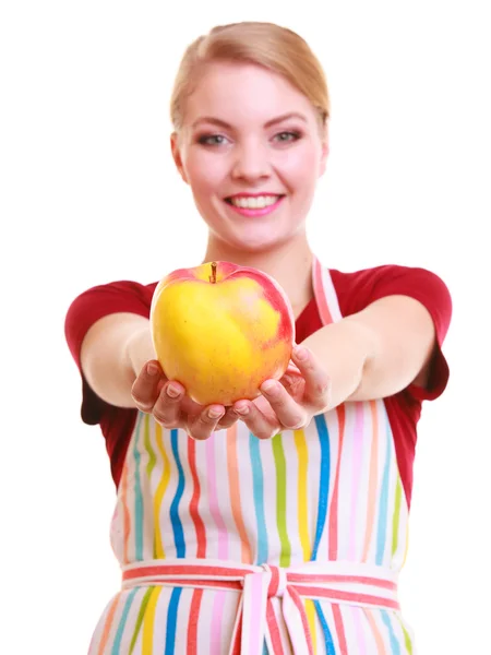 Happy housewife or chef in kitchen apron showing apple isolated — Stock Photo, Image