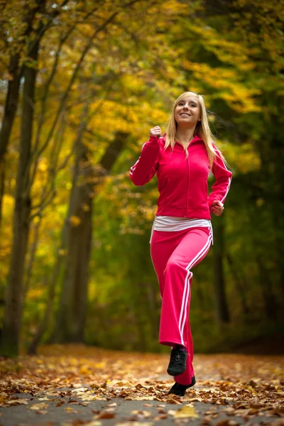 Formda sarışın bir kadın sonbahar parkında egzersiz yapıyor. Spor.. — Stok fotoğraf