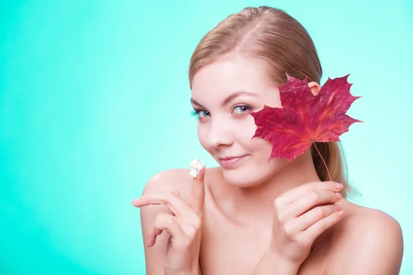 Soins de la peau. Visage de jeune femme fille avec feuille d'érable rouge. — Photo