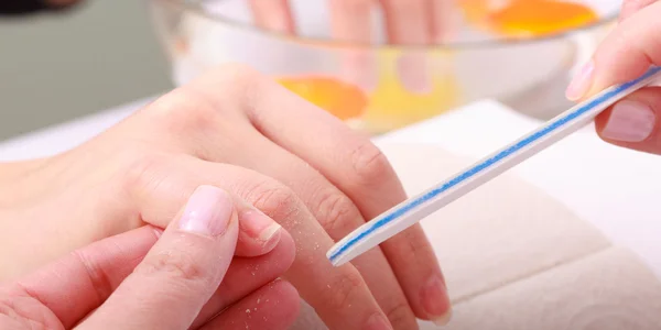 Kosmetikerin mit Feile Feilen Nägel weibliche Kundin. Frau Wellness Schönheitssalon — Stockfoto