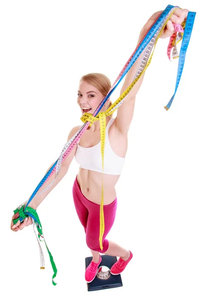 Woman with measure tape on scale celebrating weightloss — Stock Photo, Image