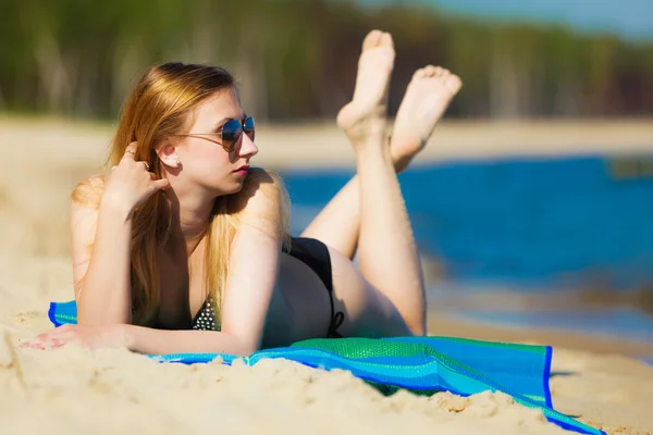 Yaz tatili. Bikinili kız sahilde güneşleniyor. — Stok fotoğraf