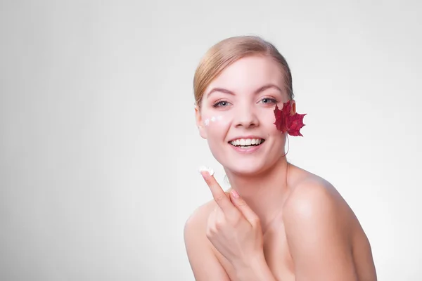 Hautpflege. Gesicht einer jungen Frau mit rotem Ahornblatt. — Stockfoto