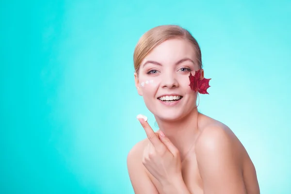 Soins de la peau. Visage de jeune femme fille avec feuille d'érable rouge. — Photo