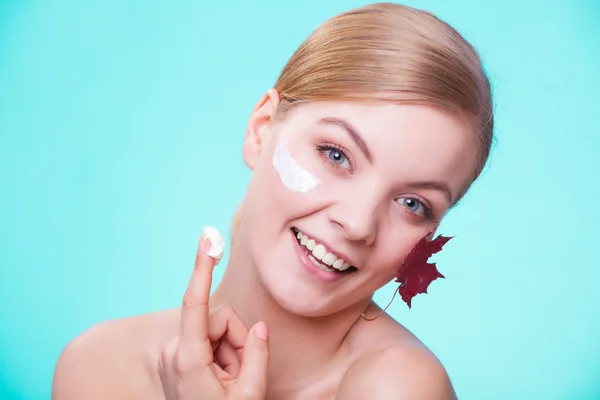 Cuidado de la piel. Cara de chica joven con hoja de arce rojo. — Foto de Stock